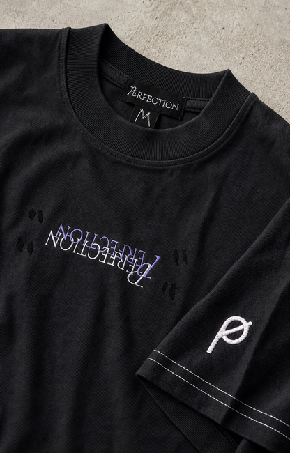 
Detailaufnahme von Kragen, Bruststickerei, Kontrastnaht und ∅-Stickerei des Recreate Yourself Tees